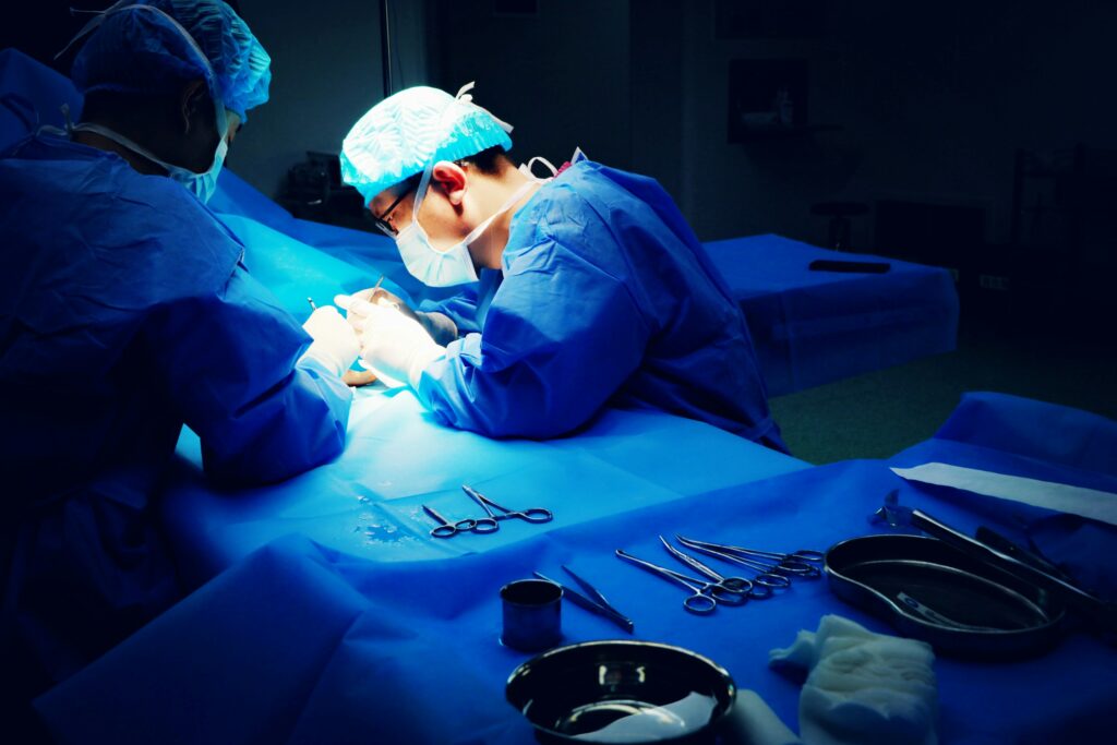 A surgical team performing a cosmetic procedure in an operating theatre, illustrating the standard of care and clinical precision involved in liposuction surgery in Asia.