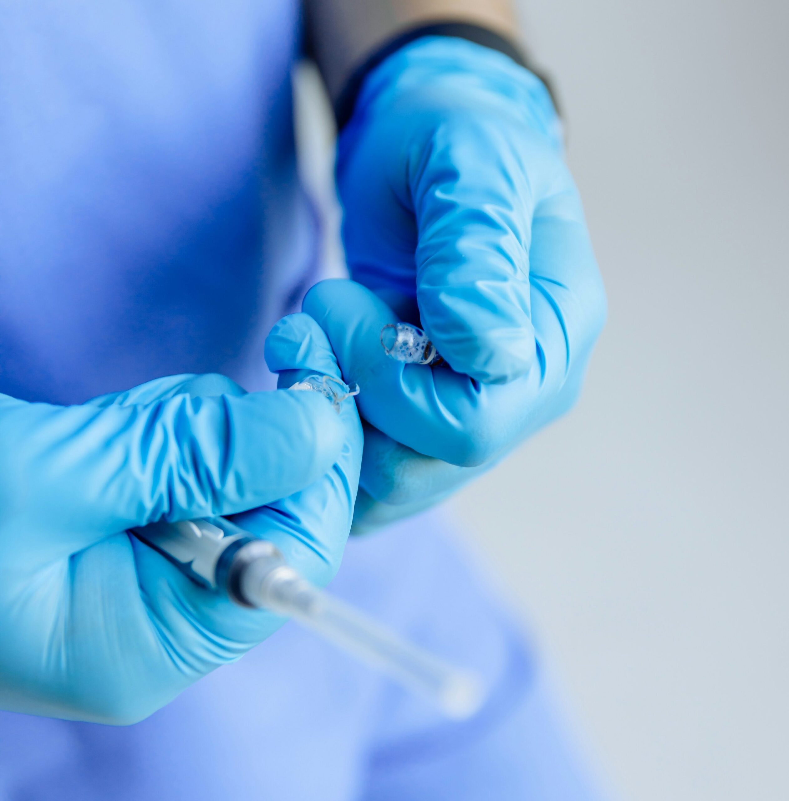 A medical professional in blue latex gloves preparing a syringe, representing the clinical precision and specialist care available through medical tourism in Thailand in 2026.
